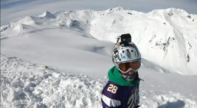 Nicola Pastres Ethical Hacker snowboarding on a mountain top.